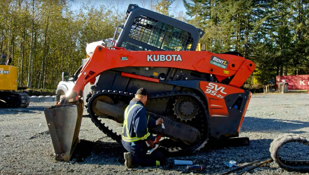 Mechanik pracujúci na oprave pásu stavebného stroja Kubota SVL 95-2s.