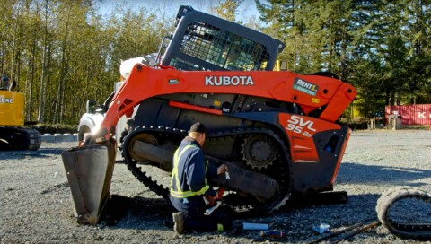 Mechanik pracujúci na oprave pásu stavebného stroja Kubota SVL 95-2s.