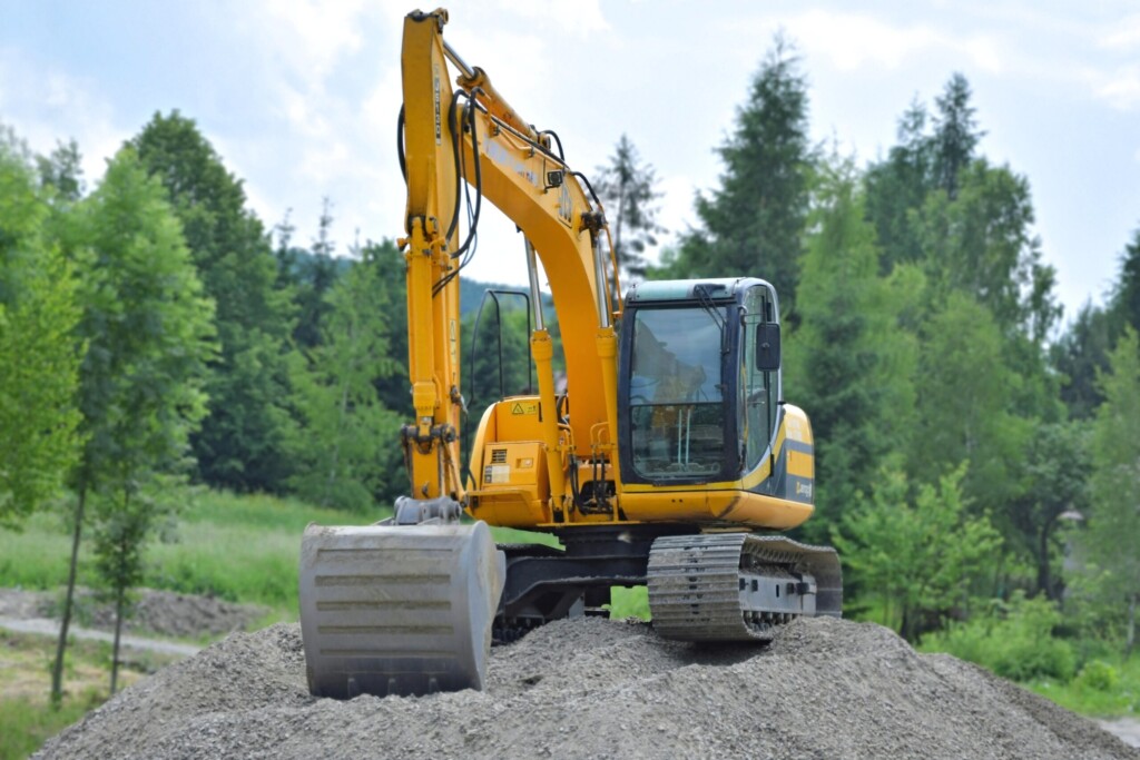 Excavator working on a gravel mound.