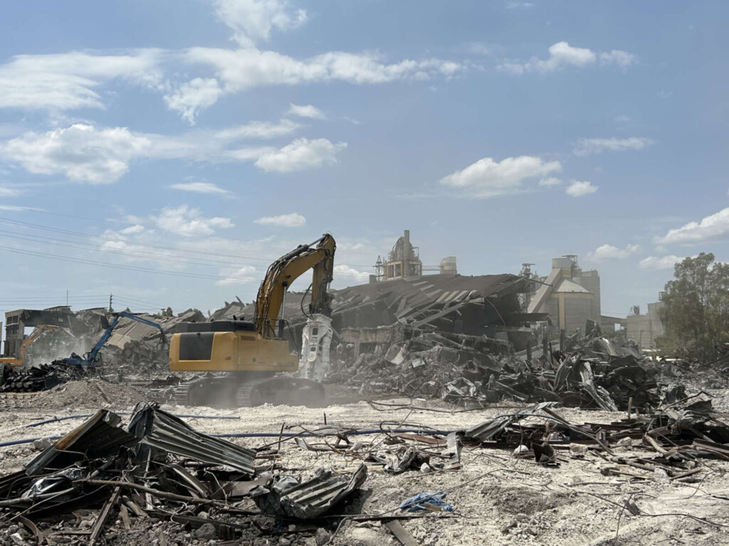 Demolačná bagrová lopata pracujúca na mieste demolácie budovy.